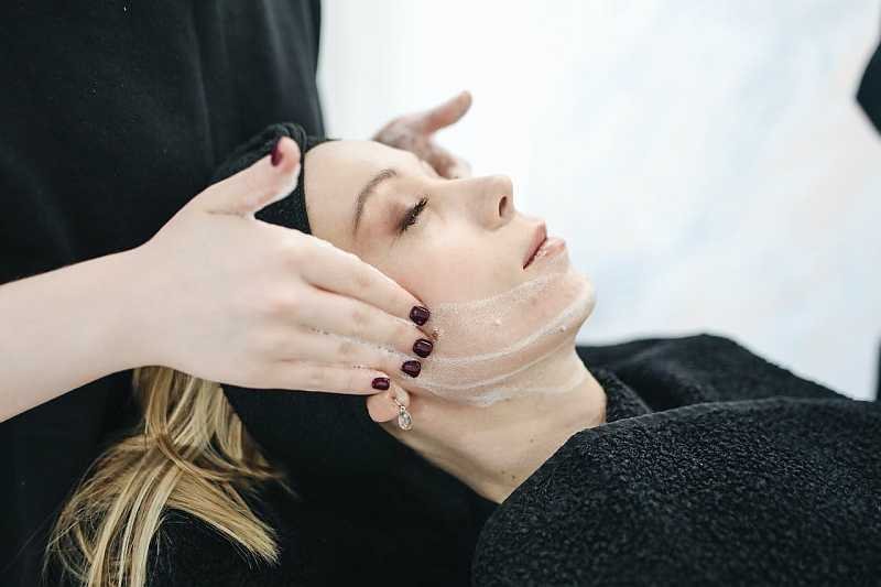 Woman having face treatment with cream