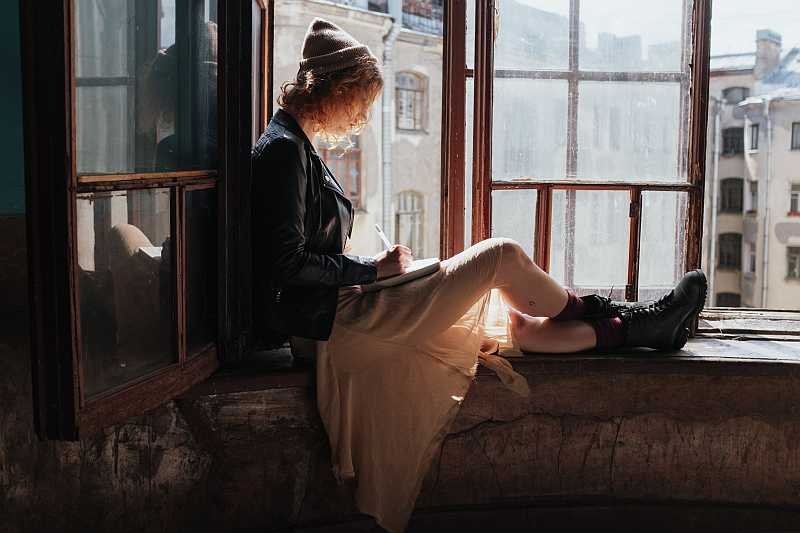 Woman sitting by the window wearing vintage